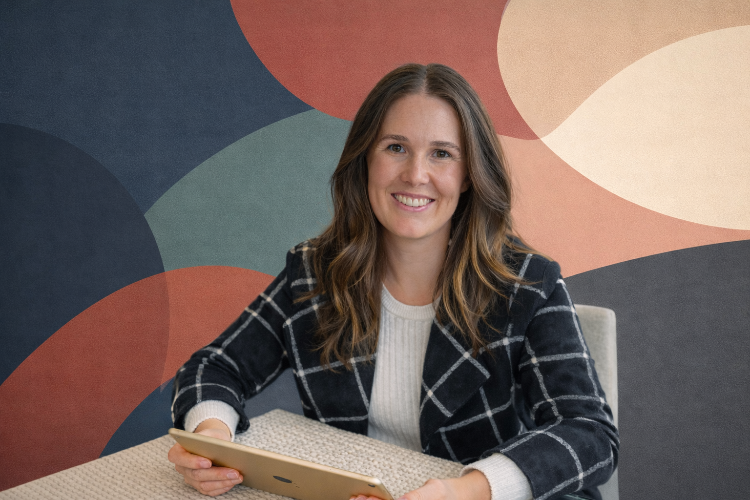 Owner of SJ Event Solutions sitting with an iPad with an abstract background